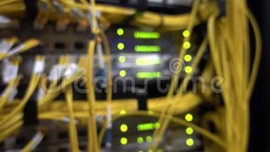 电信宽带光纤黄缆.. 数据中心架。 闪烁的绿色LED灯模糊的超级计算机。